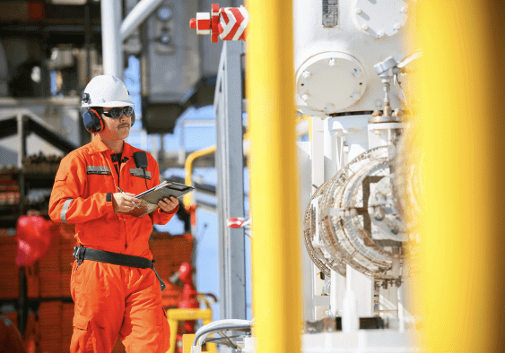 a construction work who wears an orange uniform holding a rugged tablet to operate facility inspection