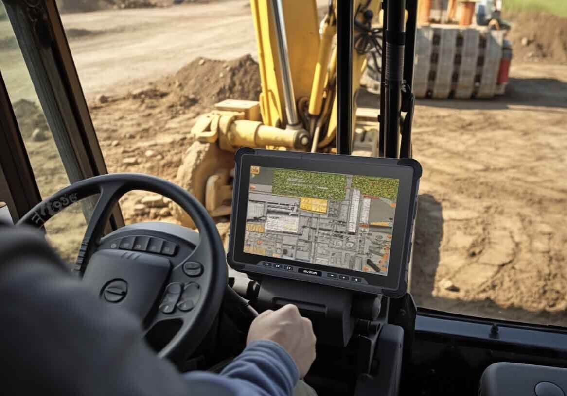 a man using a rugged tablet to take control of the construction vehicle